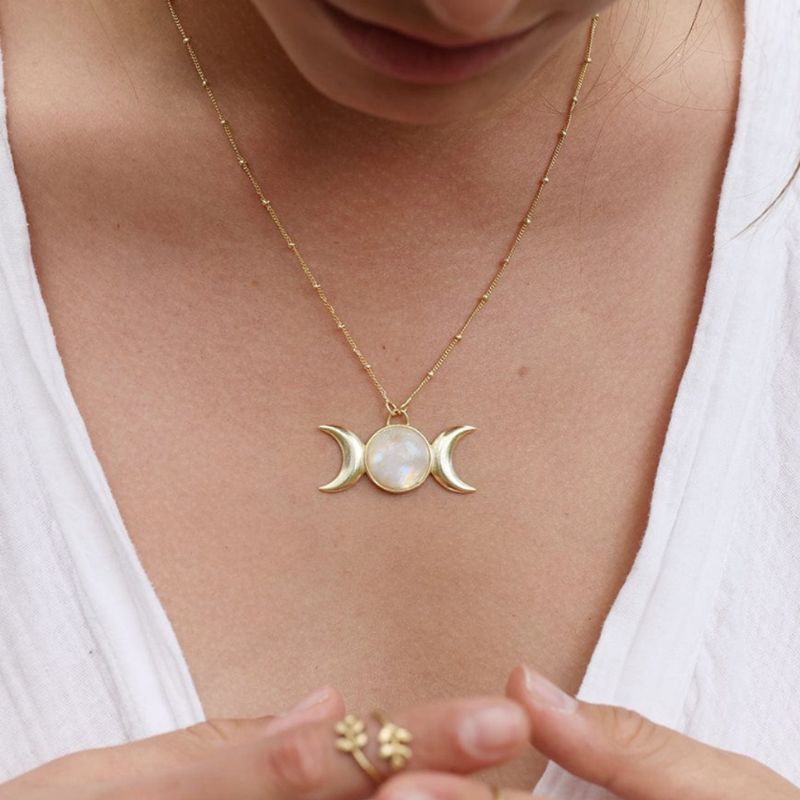 Goldene Freya-Halskette mit zentralem Mondstein, eingefasst zwischen zwei Mondsicheln.
