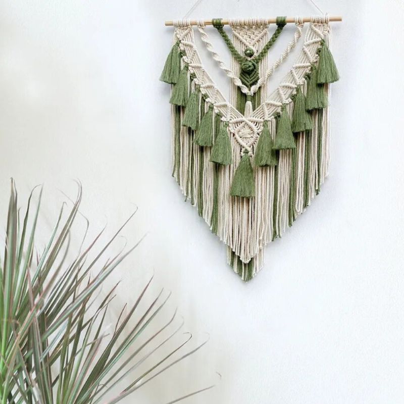 Grün beige Makramee Wandbehand mit Tasslen und Fäden die nach unten im Spitz hängen - Bohemian Wohn Dekoration für dein Zuhause 
