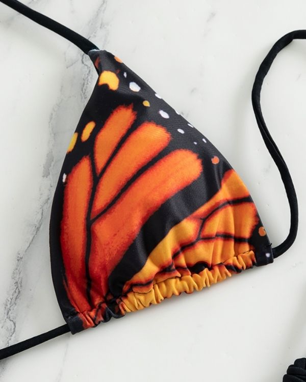Schmetterlingsprint-Bikini: Schwarz-oranges Triangel-Oberteil und String-Tanga