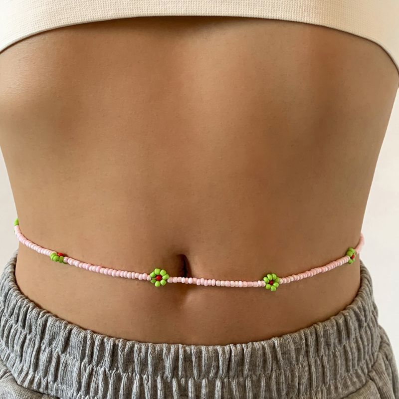 Rosa Bauchkette aus kleinen Perlen mit grünen Perlenblumen 