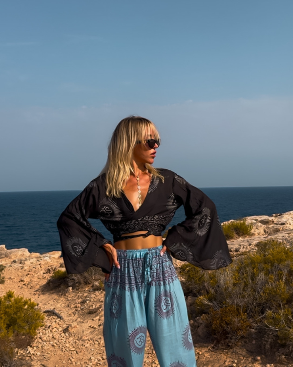 Spiritual Boho Om Outfit blaue Hose und schwarze Wickelbluse mit Trompetenärmel 