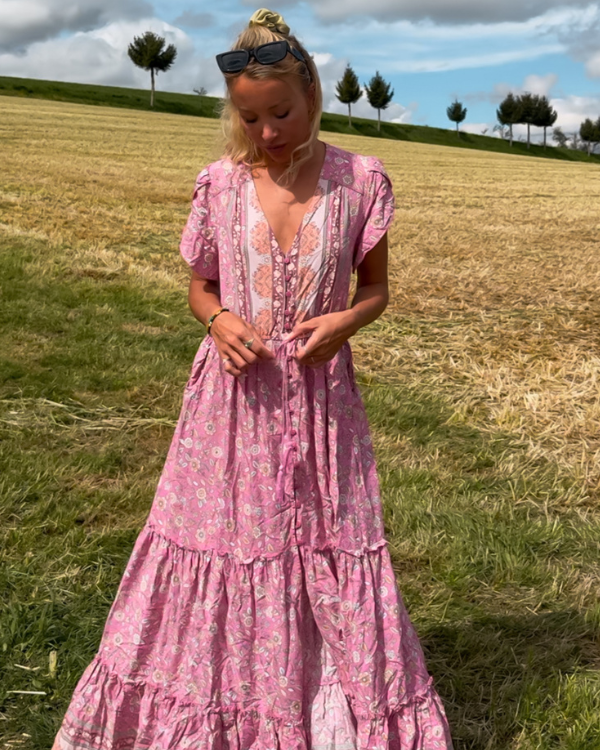 Frau trägt luftiges Maxikleid mit Blumenprint auf Wiese