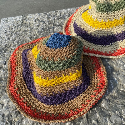 Der Stroh Häkel Hut mit farbenfrohen Streifen ist handgefertigt und somit einzigartig. Die breite Krempe schützt vor der Sonne und gibt dem Hut einen Hauch von Eleganz.
