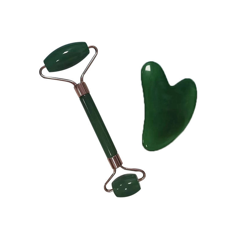 Therapeutisches Gesichtspflege-Tool: Grüner Jade-Roller und Gua Sha-Schabber auf hellem Hintergrund