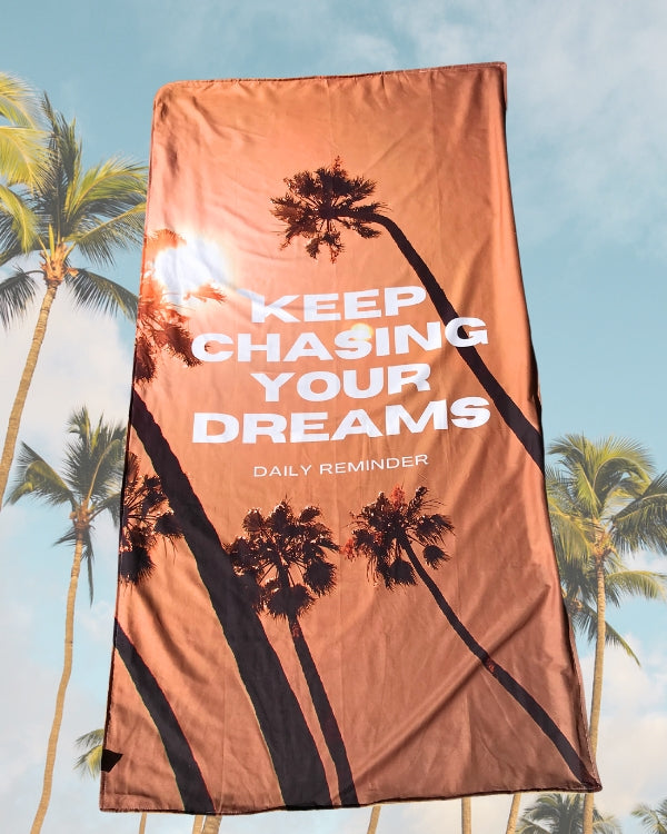 Strandtuch in braun Tönen mit Sonnenuntergang Palmen und Test "Keep Chasing your Dreams" 