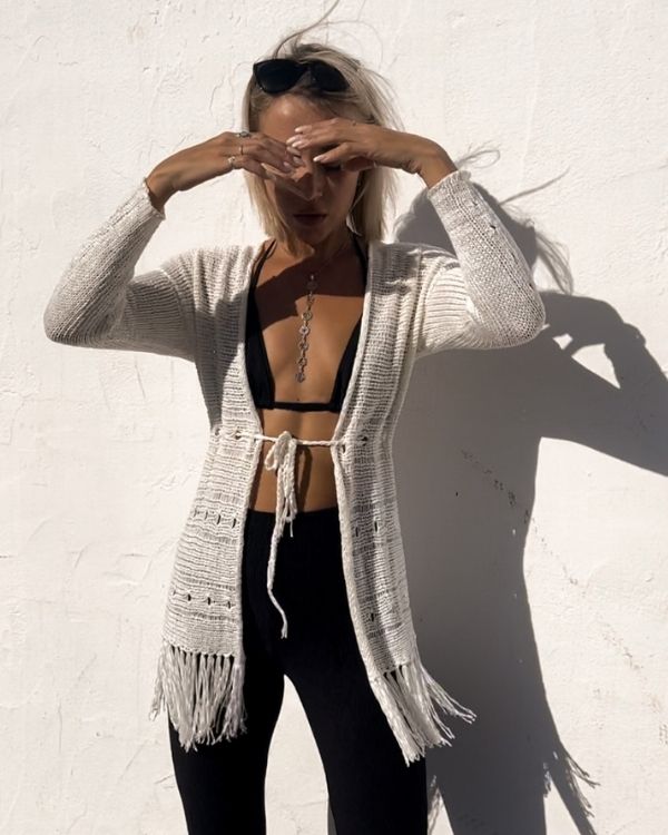 Ein gehäkelter Cardigan mit Taillengürtel und langen Ärmeln, perfekt für den Boho-Beach-Look