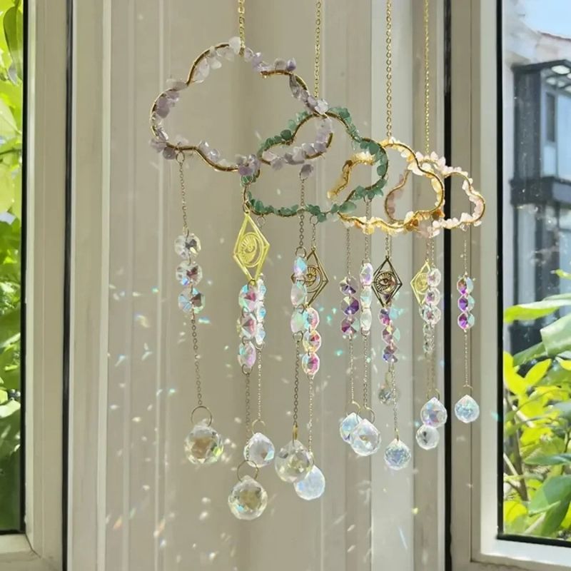 Kreativ gestalteter Fensterschmuck mit einer Wolke aus Mineralsteinen und einem zentralen goldenen Auge