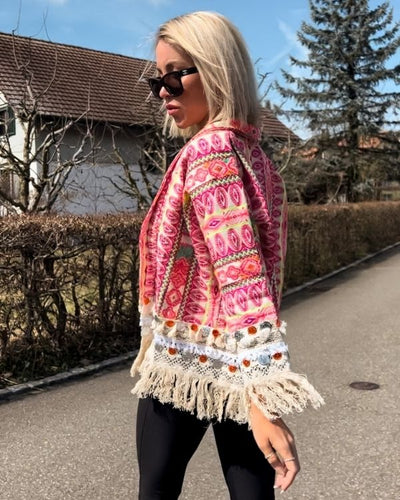 Mit ihren fransigen Details und knalligen Farben verleiht diese Boho-Jacke jedem Outfit das gewisse Extra