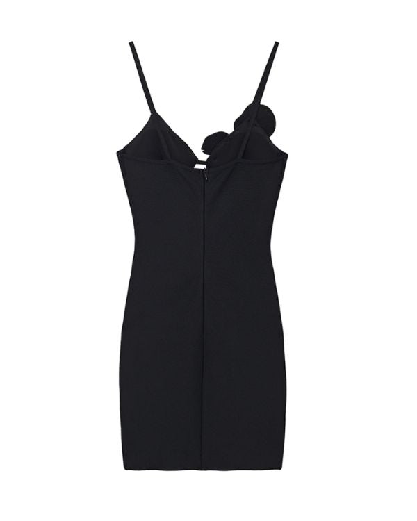schwarzes Kleid mit Glitzer Blume ueber einer Brust 