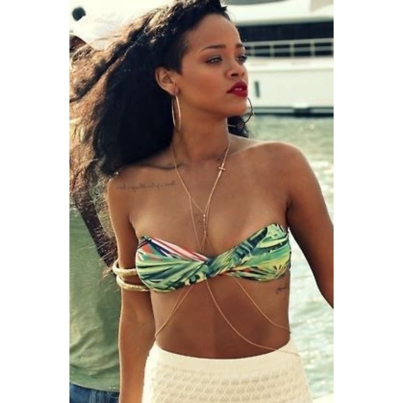 Rihanna mit goldener Koerperschmuck Bauchkette mit Kreuz Symbol 