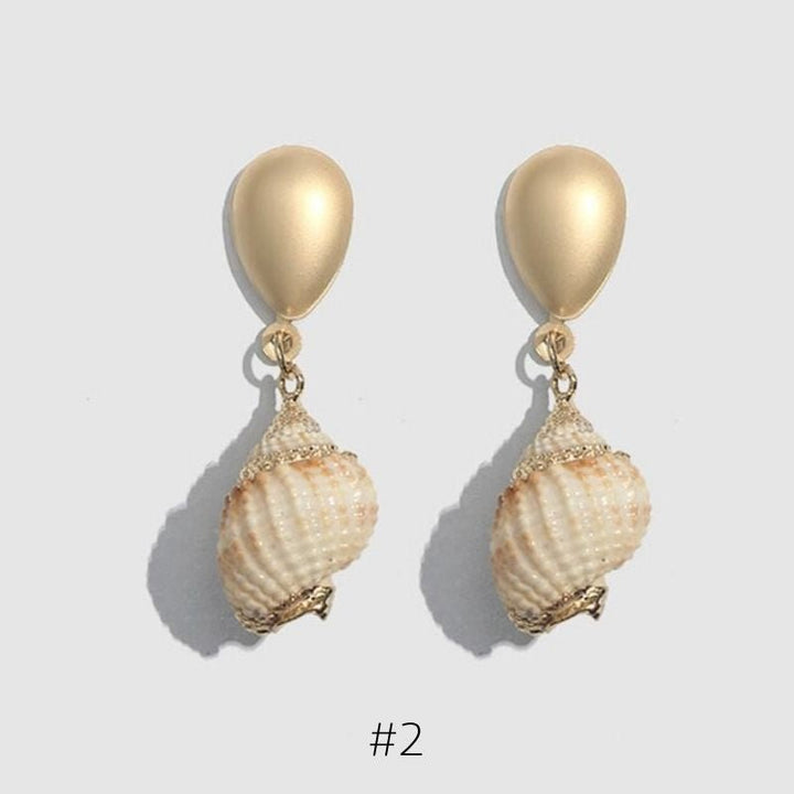 Goldene Ohrstecker mit Muschel Anhaengern und goldene Details - Elegante Modeschmuck Muschel Ohrringe
